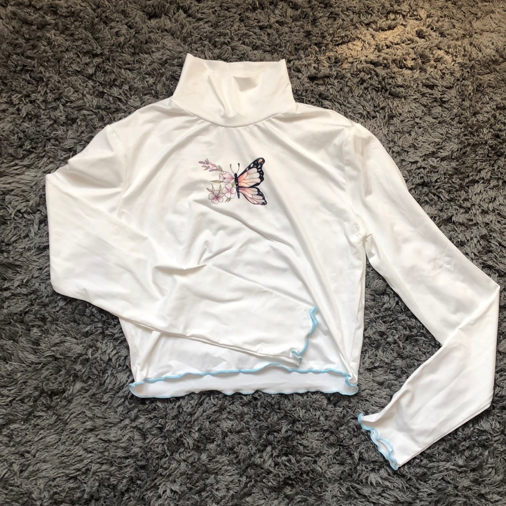 silky, white turtleneck with unique butterfly.